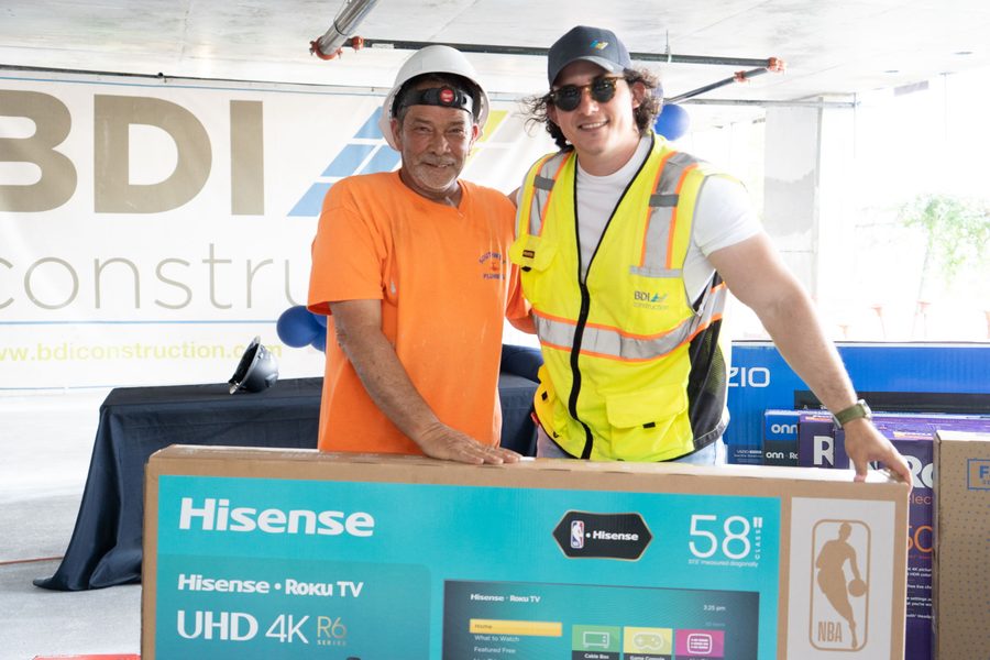 A BDI Construction team member presenting a prize to a tradesman