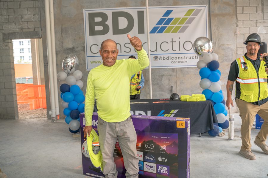A tradesman celebrating the television he won at a BDI Construction crew appreciation event