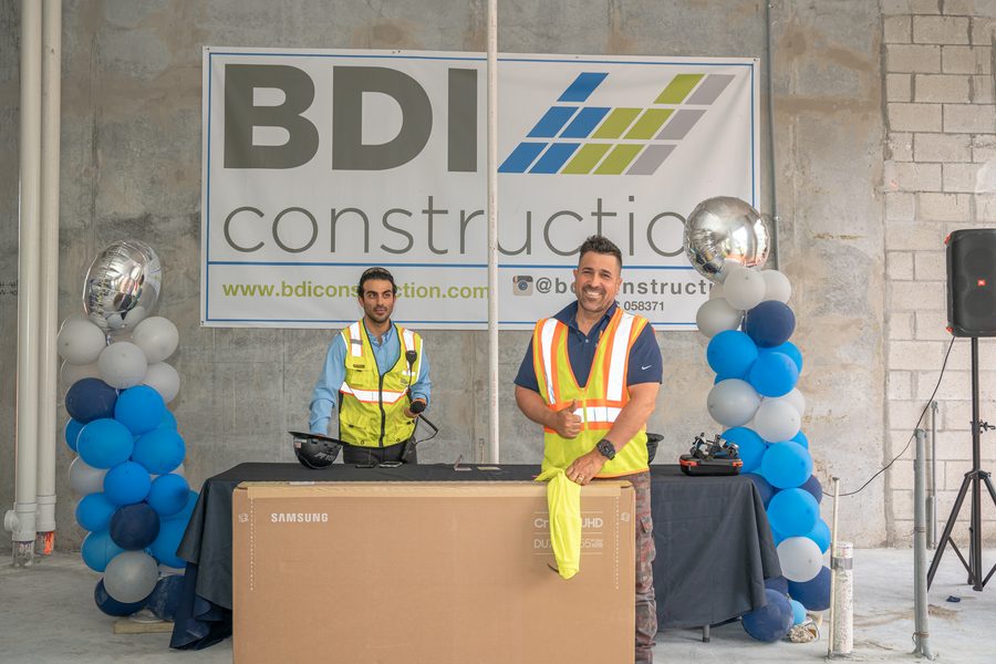 BDI Construction staff hosting a crew appreciation raffle in front of the company banner